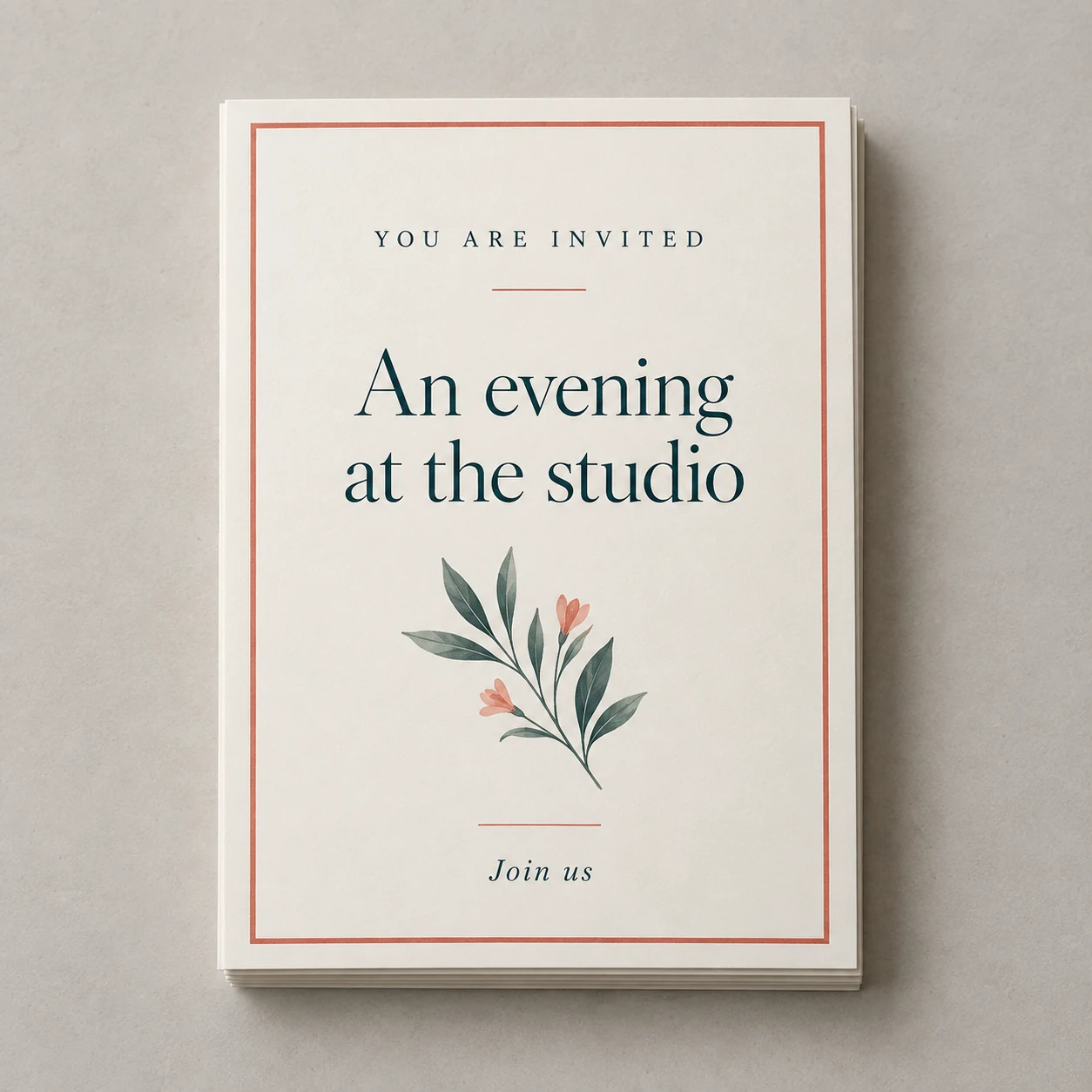 Printed flat event invitations with teal typography and a coral border photographed on a light studio surface