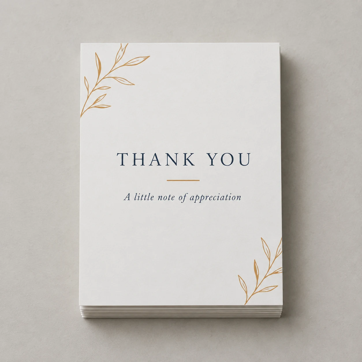 Printed flat thank-you cards with navy lettering and an ochre motif photographed on a light studio surface