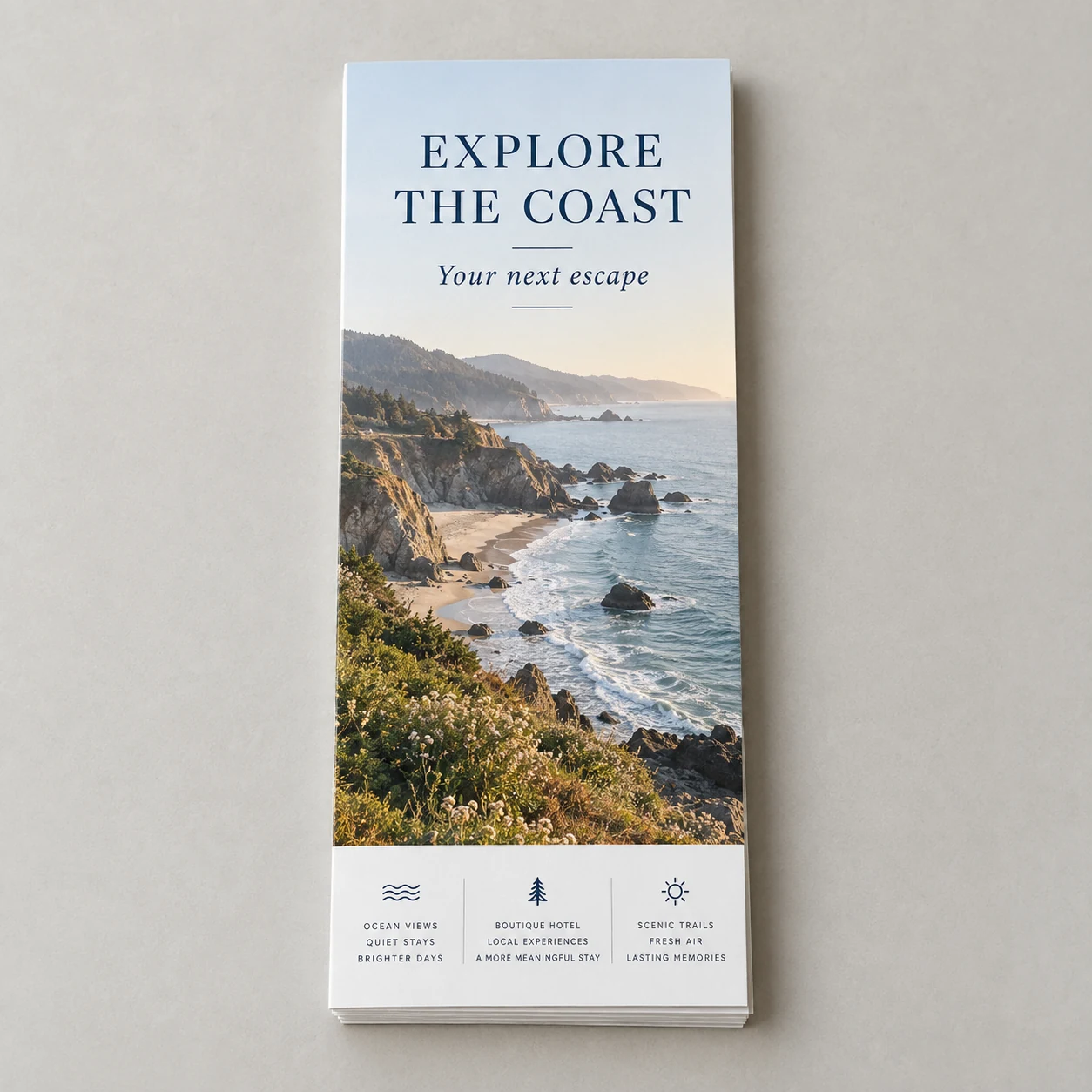 Printed coastal travel rack cards with a seaside photograph photographed on a light studio surface