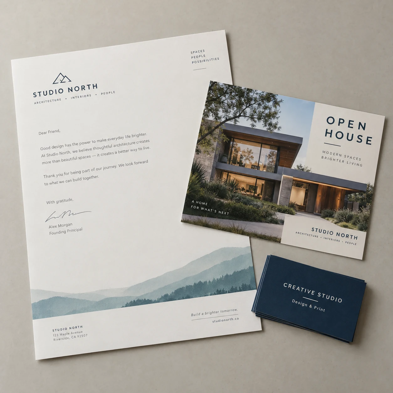 Coordinated studio business cards, an open-house postcard and branded letterhead photographed together