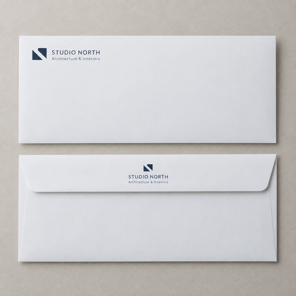 Printed business envelopes showing a studio header and back flap photographed on a light studio surface